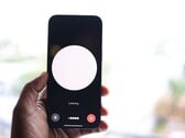 Рука, держащая смартфон с интерфейсом голосового помощника на экране