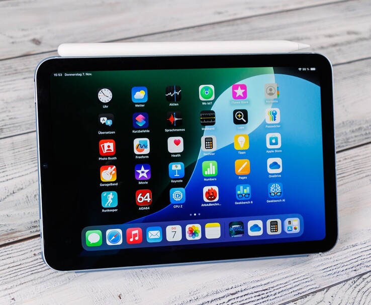 Вид спереди iPad mini с лежащим сверху карандашом Apple Pencil, на котором отображается домашний экран, когда он лежит на деревянной поверхности. (Источник изображения: Notebookcheck)