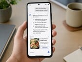 Рука, держащая смартфон, на экране которого отображается ответ, сгенерированный искусственным интеллектом, а под ним — спонсорская реклама