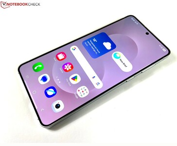 Крупный план Samsung Galaxy S25 Edge показывает его плоский дисплей, тонкие ободки и домашний экран, на котором видны значки погоды и приложений. (Источник изображения: Notebookcheck)