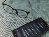 Смартфон с запущенным приложением ChatGPT, расположенный рядом с очками на поверхности с узором