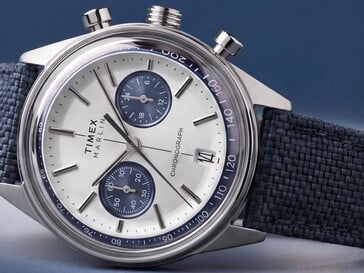 Хронограф Timex Marlin Jet, сфотографированный на тёмном фоне, демонстрирует своё выпуклое стекло, безель с тахиметром, вогнутый циферблат, вспомогательные циферблаты хронографа и ретрофутуристический дизайн корпуса.