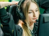 Стример в игровых наушниках с микрофоном-штангой, сидящий перед экраном во время прямой трансляции
