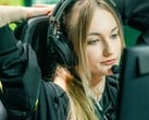 Стример в игровых наушниках с микрофоном-штангой, сидящий перед экраном во время прямой трансляции