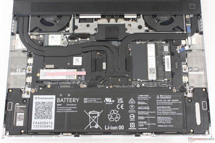 Laptop 16 со снятой клавиатурой, тачпадом и промежуточной панелью. На большинстве компонентов есть QR-код для быстрого заказа