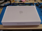 Розничная коробка MacBook Neo помещена на верстак перед разборкой для обновления SSD