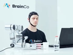 Пользователь технологии управления сознанием компании BrainCo механически берет яблоко, используя исключительно силу мысли.
