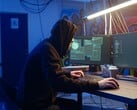 Обычный хакер за рабочей станцией с двумя мониторами выполняет атаку на цепочку поставок.