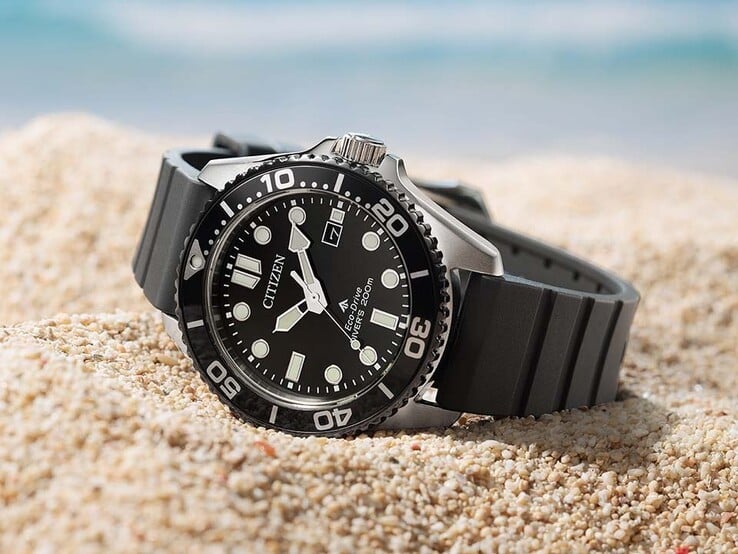 Часы Citizen Promaster Marine BN0266-07E с чёрным циферблатом, чёрным безелем и чёрным ремешком, лежащие на песке.