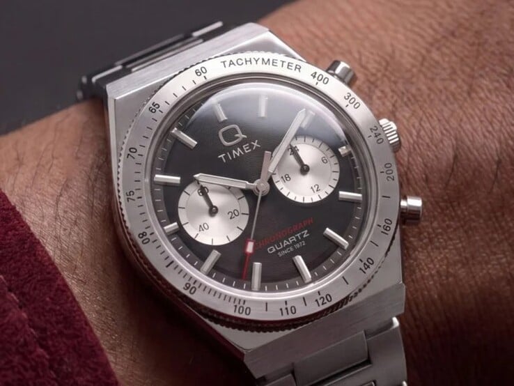 Часы Timex Q Timex Continental Chronograph TW2Y93200 на запястье, с чёрным радиальным циферблатом в стиле CD, двумя серебристыми дополнительными циферблатами, безелем с тахиметром, светящимися метками и интегрированным браслетом из нержавеющей стали.