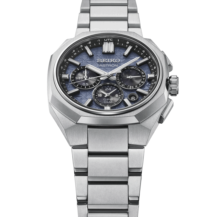 Вид спереди на часы Seiko Astron HAB001 с граненым титановым безелем, интегрированным браслетом и текстурированным синим циферблатом.