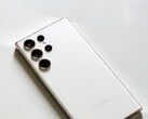 Белый смартфон Samsung Galaxy с четырьмя камерами на задней панели на светлой поверхности