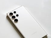 Белый смартфон Samsung Galaxy с четырьмя камерами на задней панели на светлой поверхности