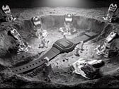 Цифровые часы Casio x GRAGG LW-204GRAGG-1BDF представлены на скульптурной серебряной подставке в окружении миниатюрных космонавтов и объектов, стилизованных под расплавленный металл.