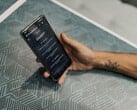 Рука держит смартфон с открытым приложением ChatGPT над столом с узорчатой поверхностью