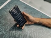 Рука держит смартфон с открытым приложением ChatGPT над столом с узорчатой поверхностью