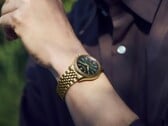 Часы Seiko Presage Classic x Tradman’s Bonsai на запястье с корпусом и браслетом золотистого цвета и темно-зелёным циферблатом.