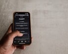 Рука, держащая смартфон с интерфейсом ChatGPT над серой каменной поверхностью