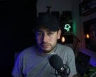Автор контента в домашней студии с микрофоном и камерой, демонстрирующий работу в рамках Партнерской программы YouTube
