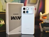 Смартфон первого поколения Honor Win на фоне своей коробки.