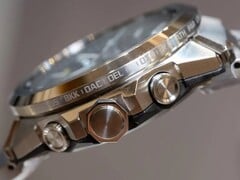Вид сбоку на часы Casio G-Shock серии GST-W1000, на котором видны корпус из нержавеющей стали, кнопки, заводная головка, цельный браслет и выгравированные названия городов по всему безелю.