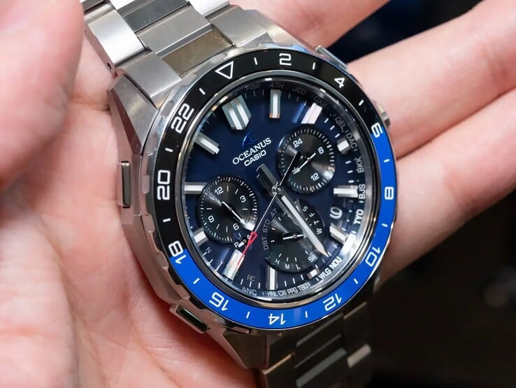 Крупный план синего циферблата часов Casio Oceanus OCW-P3000 с указанием кодов городов, дополнительных циферблатов, светящихся часовых меток и широких стрелок.
