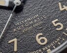 Крупный план текстурированного чёрного циферблата часов Timex Expedition Field Post Titanium с арабскими цифрами, светящимися стрелками и индексами, а также окошком даты.