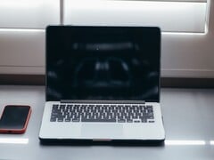 Расположите ноутбук и смартфон рядом друг с другом на столе при дневном освещении