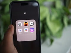 Рука держит смартфон с папкой, полной приложений с ИИ, на экране