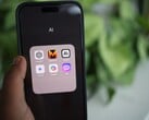 Рука держит смартфон с папкой, полной приложений с ИИ, на экране