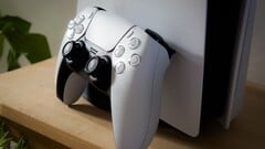 Изображение контроллера PlayStation 5 DualSense, прислонённого к консоли PS5
