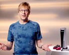  Марк Серни во время мероприятия PlayStation, сидящий рядом с консолью PS5 и контроллерами DualSense. (Источник изображения: Sony Interactive Entertainment)