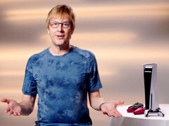  Марк Серни во время мероприятия PlayStation, сидящий рядом с консолью PS5 и контроллерами DualSense. (Источник изображения: Sony Interactive Entertainment)