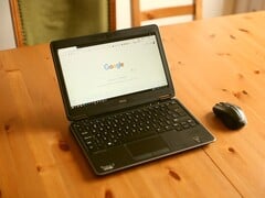 Ноутбук с ОС Windows, стоящий на деревянном столе, с открытой в браузере главной страницей Google