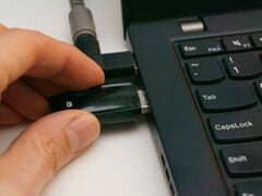 Человек вставляет USB-ключ безопасности в ноутбук