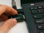 Человек вставляет USB-ключ безопасности в ноутбук