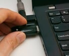 Человек вставляет USB-ключ безопасности в ноутбук