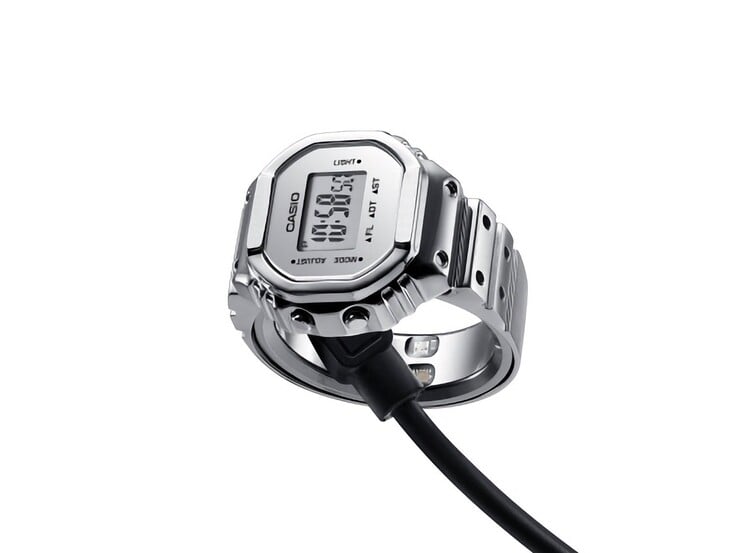 Умные часы-кольцо Casio CRW-H001M-8, подключенные к магнитному USB-кабелю для зарядки.