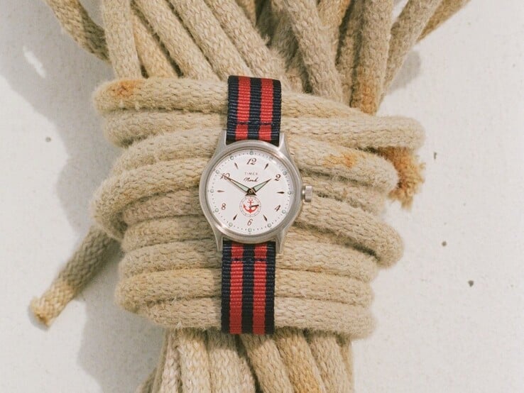 Часы Noah x Timex MK1 Anchor с серебристым корпусом диаметром 36 мм, белым циферблатом, изображением якоря и тканевым ремешком в полоску синего и красного цветов.