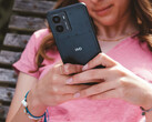 Рекламное изображение смартфона Fusion от HMD, на котором изображен телефон в руках женщины и крупным планом логотип HMD на задней панели. (Источник изображения: HMD)