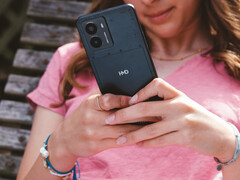Рекламное изображение смартфона Fusion от HMD, на котором изображен телефон в руках женщины и крупным планом логотип HMD на задней панели. (Источник изображения: HMD)