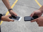 Два человека держат два смартфона рядом друг с другом во время передачи