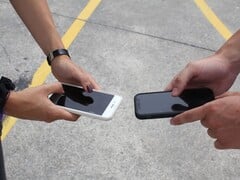 Два человека держат два смартфона рядом друг с другом во время передачи