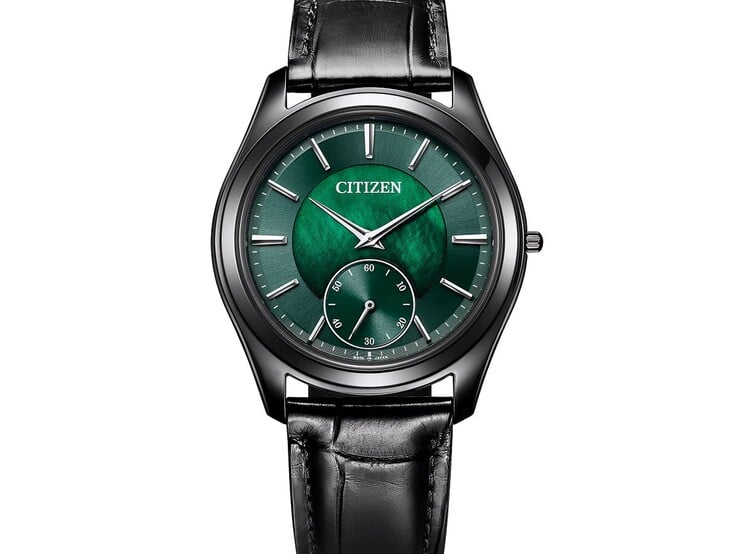 Крупный план Citizen Eco-Drive One AQ5025-04N под углом: мерцающий зеленый перламутровый циферблат, стрелки и метки серебристого тона, черный корпус и кожаный ремешок.