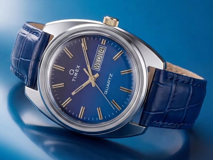 Фотография Timex Q 1976 Day and Date под углом, подчеркивающая синий градиентный циферблат, полированный корпус из нержавеющей стали и заводную головку золотистого цвета.