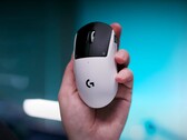 Игровая мышь Logitech G Pro X2 Superstrike в руке на синем фоне