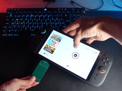 Ю с YouTube-канала Better Gaming держит в одной руке Nintendo Switch 2, а в другой - зеленый адаптер PCB с открытым исходным кодом, пытаясь вставить его в слот microSD Express устройства (Источник изображения: Better Gaming на YouTube)
