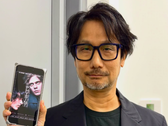 Hideo Kojima показывает постер Physint на своём телефоне