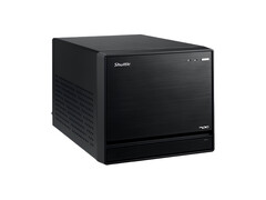 На изображении показан вид с головы на Shuttle XPC Mini PC, который выглядит как черный куб с минимальным дизайном. 