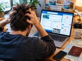 Человек сидит за ноутбуком и испытывает трудности с бронированием поездки